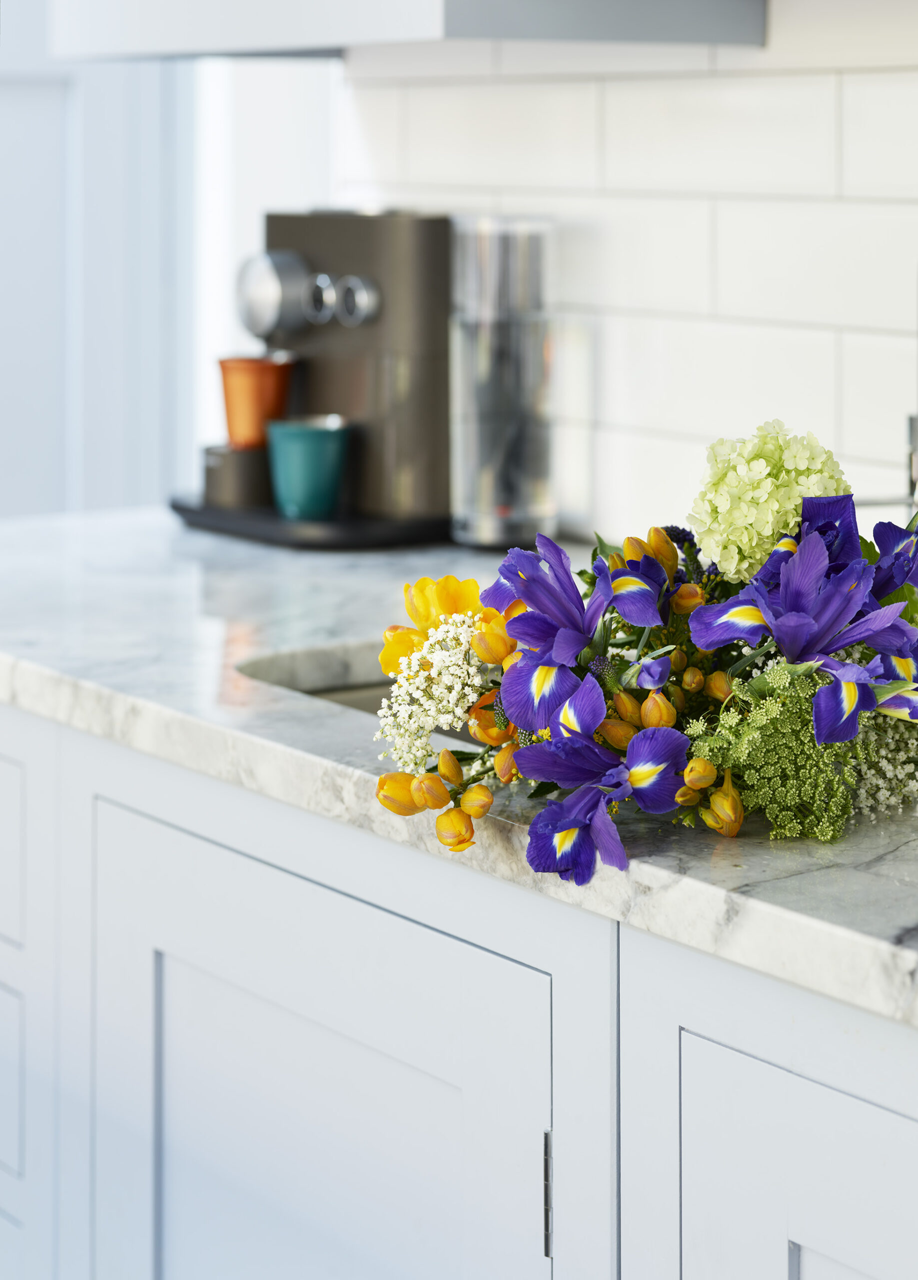 Pale blue Shaker kitchen cabinetry with white marble worktop