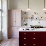 Arbor kitchen design featuring a burgundy kitchen island, blush pink cabinetry and dark wooden flooring