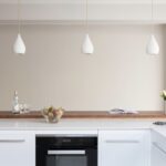 White Linear kitchen island featuring oven and white worktop with dark oak extension