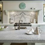 Grey marble kitchen island worktop with integrated sink featuring a brass tap