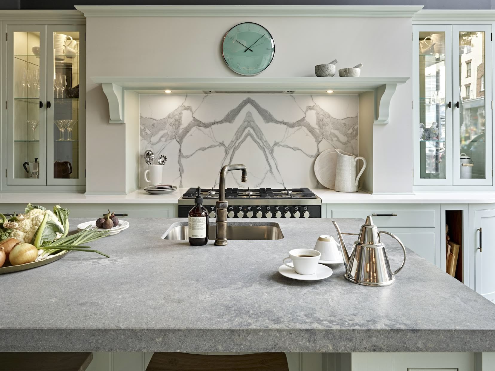 Grey marble kitchen island worktop with integrated sink featuring a brass tap