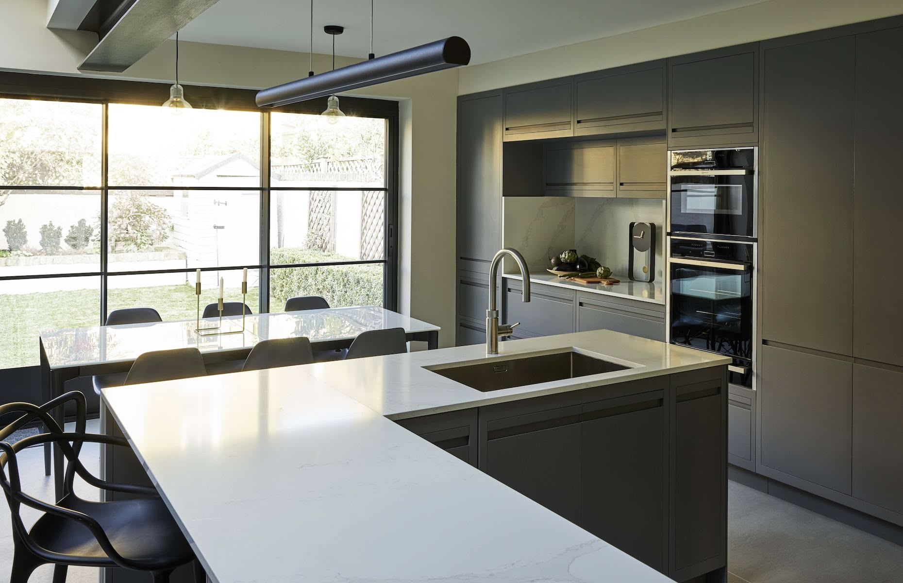 Large grey kitchen island with integrated sink and white marble worktop
