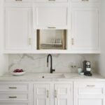 White kitchen cabinetry with open plate rack