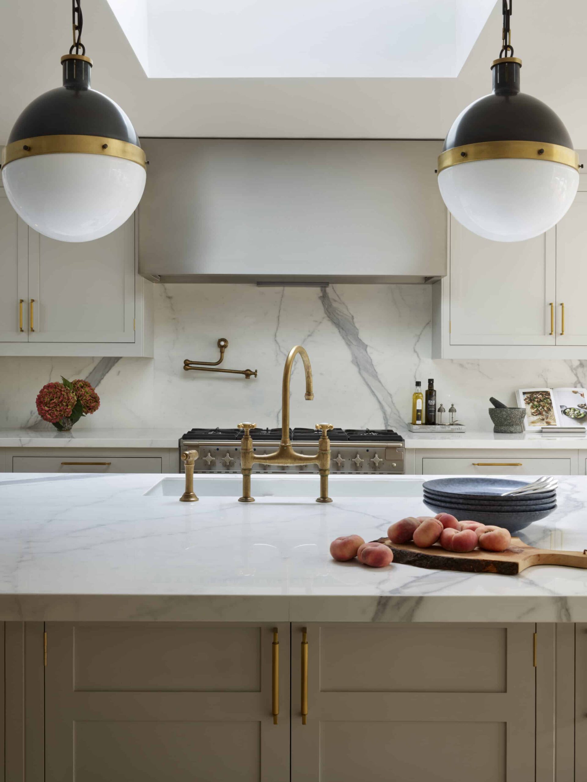 Soft grey kitchen island with integrated sink and gold tap