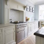 Off-white kitchen cabinetry and cooker with white tiled splashback
