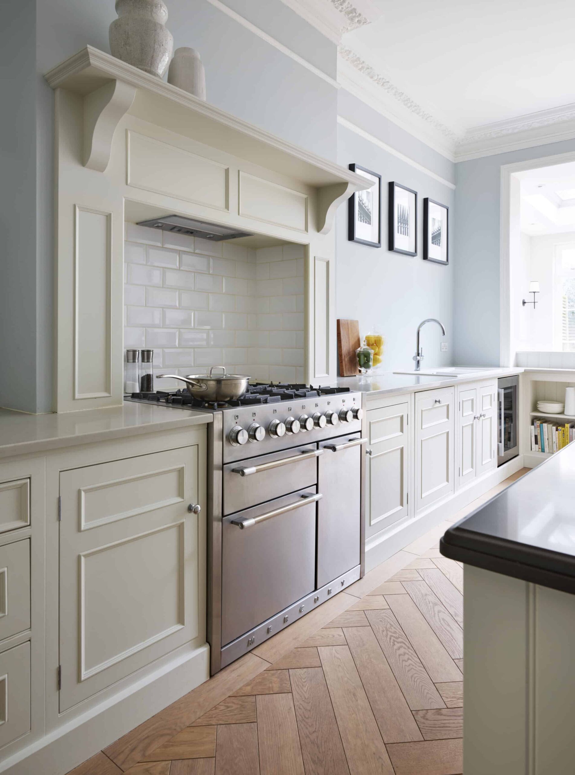Off-white kitchen cabinetry and cooker with white tiled splashback