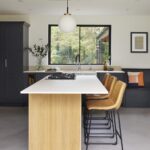 Light oak Shaker kitchen island with light grey worktop and orange stools