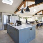 Blue kitchen island featuring Arbor cabinetry and natural wood worktop