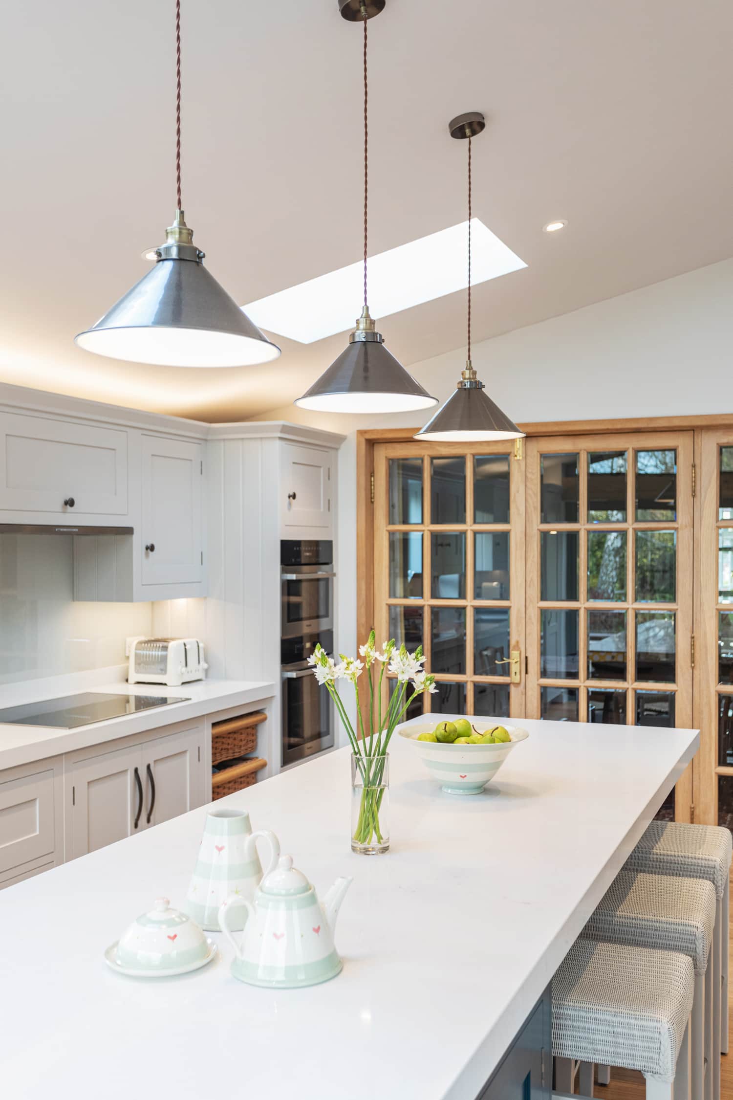 White kitchen island worktop featuring white bar stools and white Shaker kitchen cabinetry