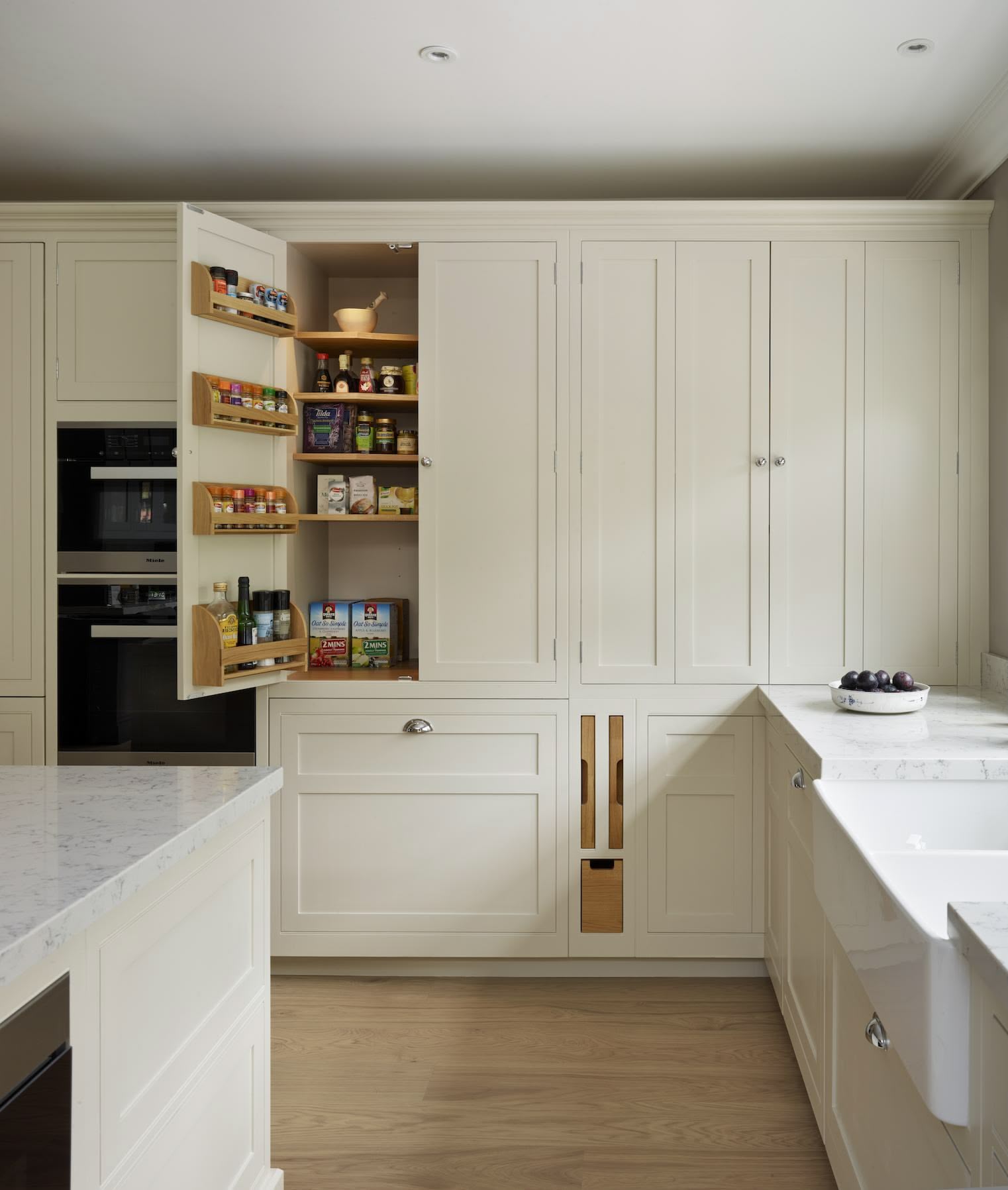 Harvey Jones white kitchen cabinetry open to show organised storage