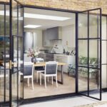 External view of open plan Original kitchen design with open plan dining area through black French doors