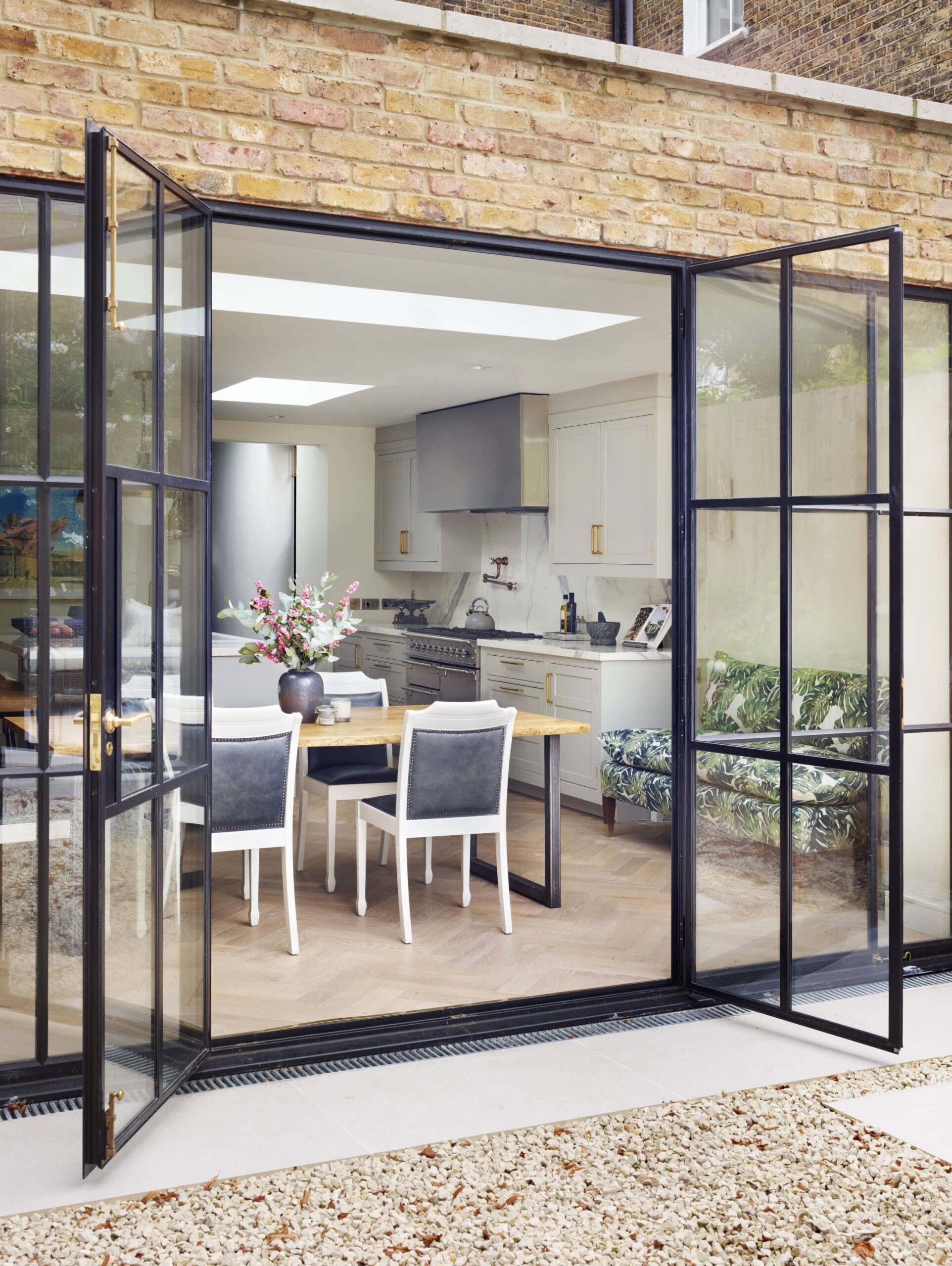 External view of open plan Original kitchen design with open plan dining area through black French doors