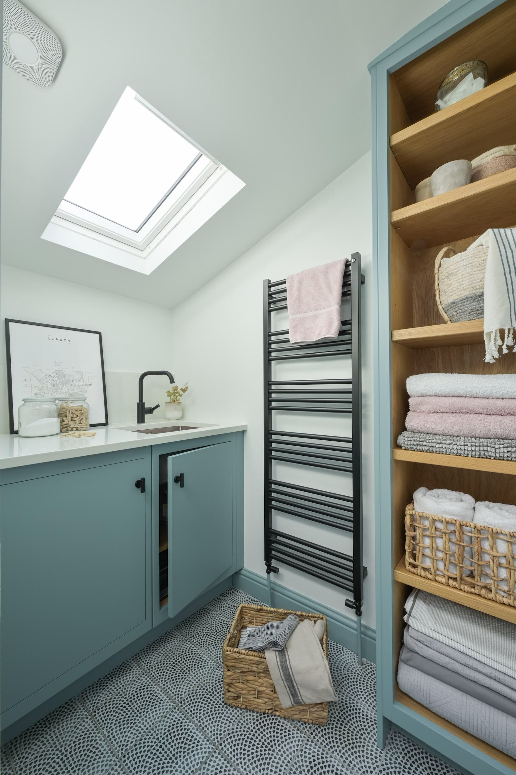 Pale blue utility room cabinetry showing organised shelving and sink