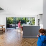 Children situated in bright Shaker kitchen