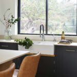 White basin sink integrated with dark Shaker kitchen cabinetry
