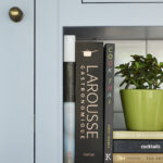 Closeup of pale blue Shaker kitchen cupboard and book shelf