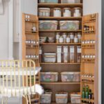 White Shaker kitchen pantry open to show oak interior and organised storage