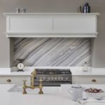 Cream Original kitchen cabinetry with black and white marble splashback against the cooker