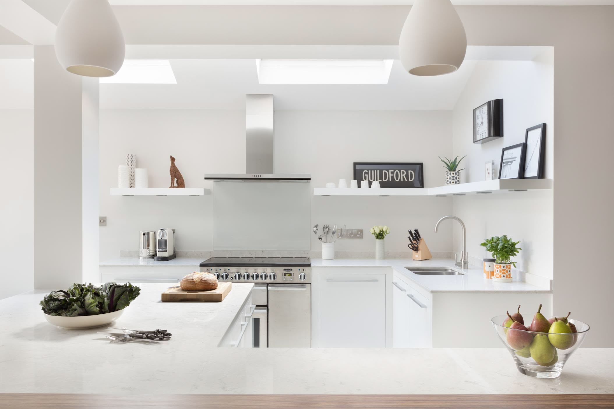 Bright Linear kitchen design featuring white kitchen cabinetry