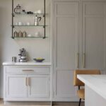 Glass open shelving above white kitchen cabinetry