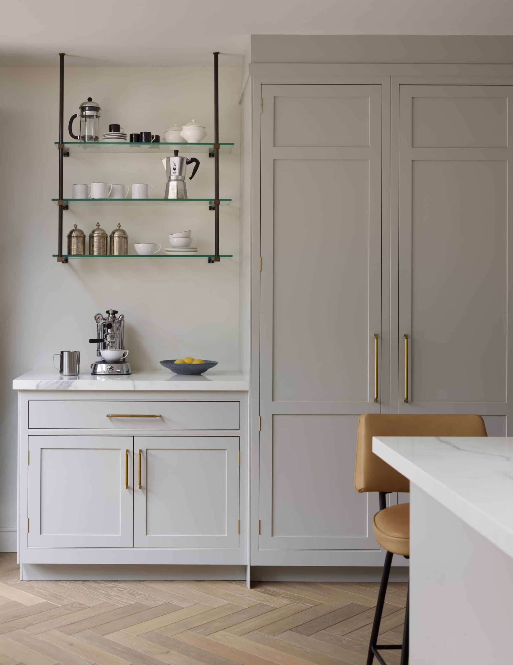 Glass open shelving above white kitchen cabinetry