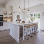 White Original kitchen design featuring soft grey kitchen island and natural coloured stools