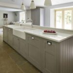 Grey kitchen island with white worktop and integrated basin sink