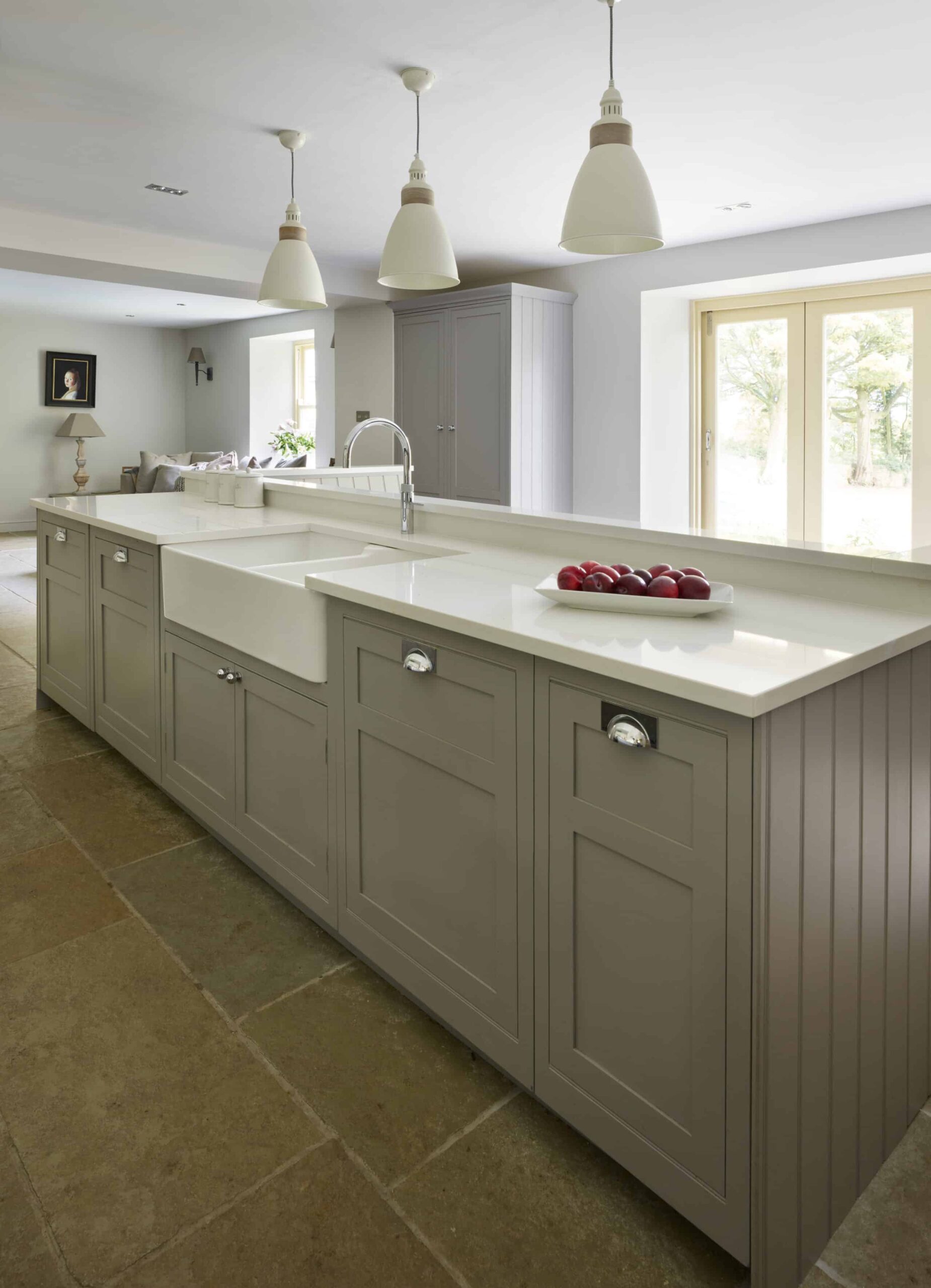 Grey kitchen island with white worktop and integrated basin sink