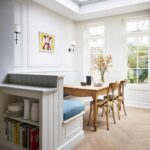 Open plan dining area with bench seating featuring book shelves