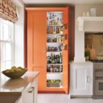 Organge Shaker kitchen pantry open to reveal organised storage