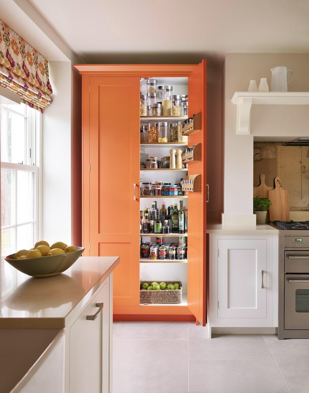Organge Shaker kitchen pantry open to reveal organised storage
