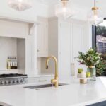Blue Shaker kitchen island with gold handles, white worktop and integrated sink with gold tap