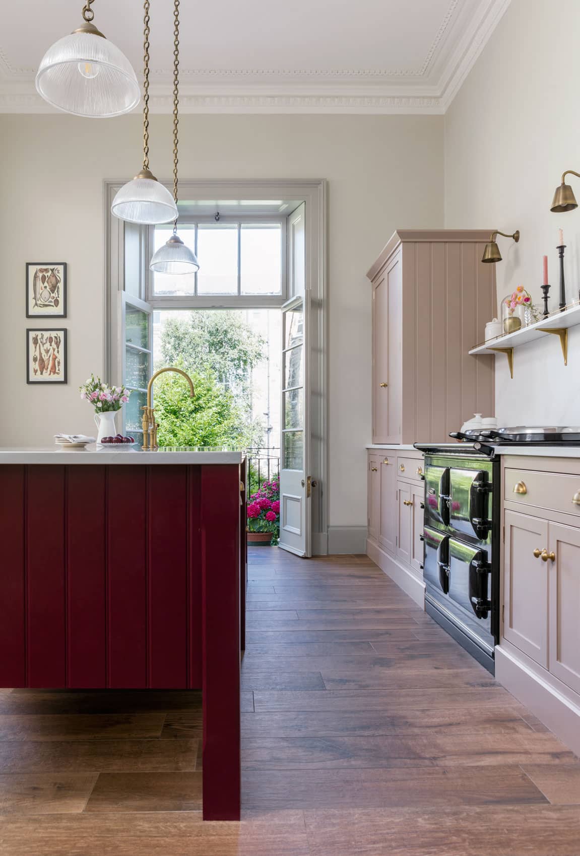 Arbor kitchen design with blush pink cabinetry and burgundy kitchen island featuring a white worktop