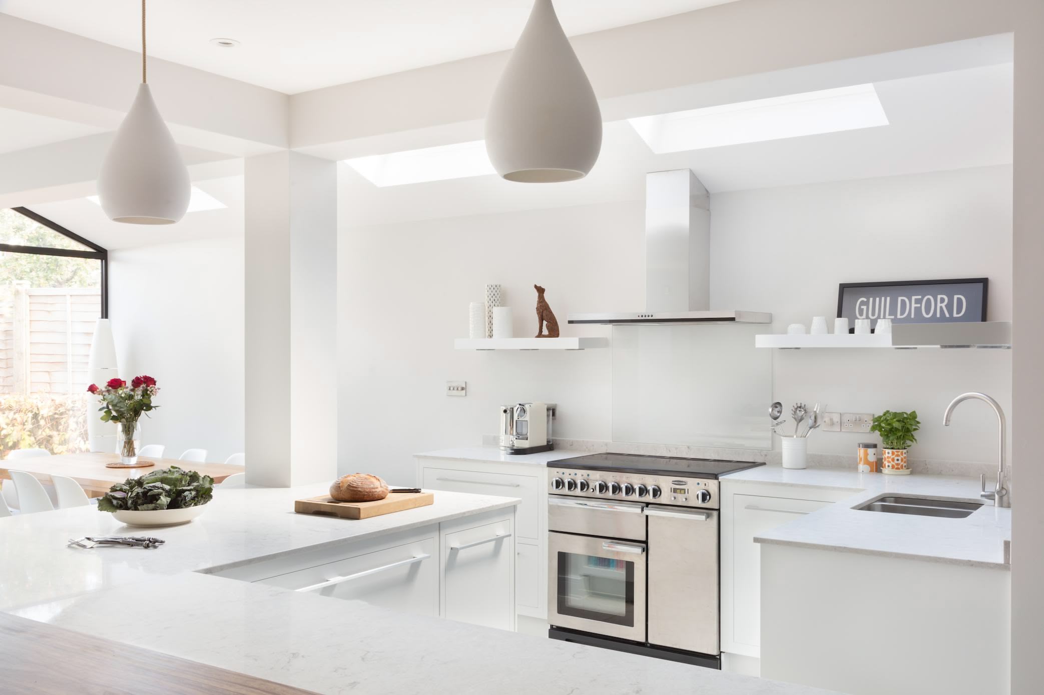 Bright Linear kitchen design featuring white kitchen cabinetry