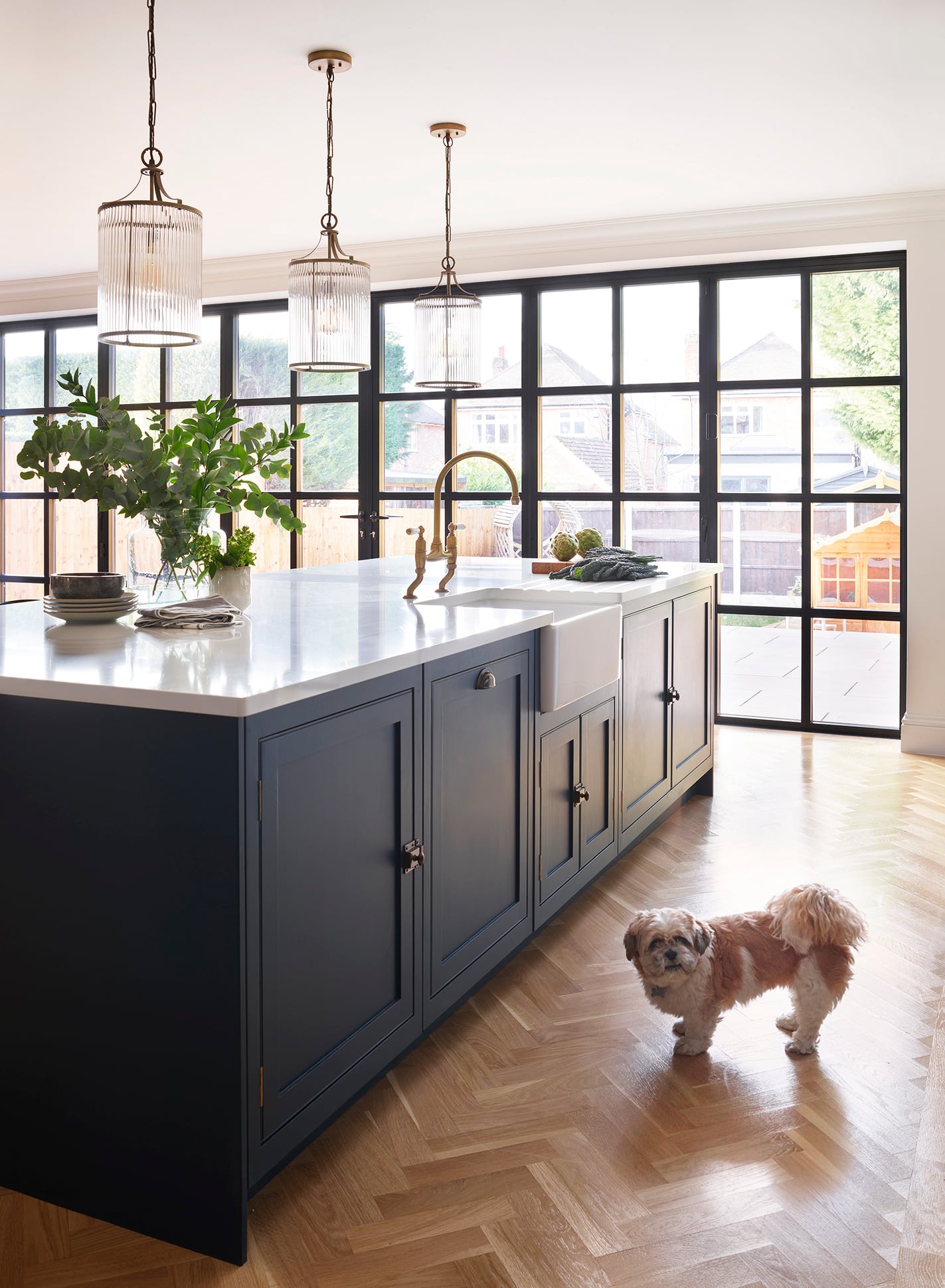 Deep blue kitchen island with white basin sink and gold tap