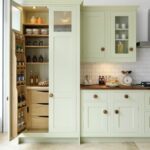 Large green pantry with double doors, open to reveal organised storage and drawers