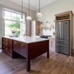 Arbor kitchen design featuring blush pink cabinetry, burgundy kitchen island and large silver American style refigerator