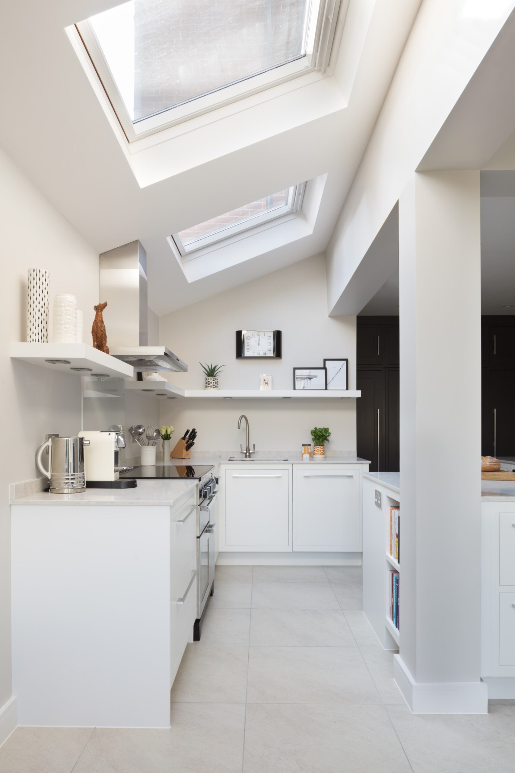 Bright Linear kitchen design featuring white kitchen cabinetry