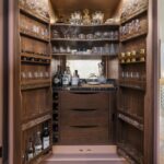 Large open dark pantry with double doors showing organised storage and drawers