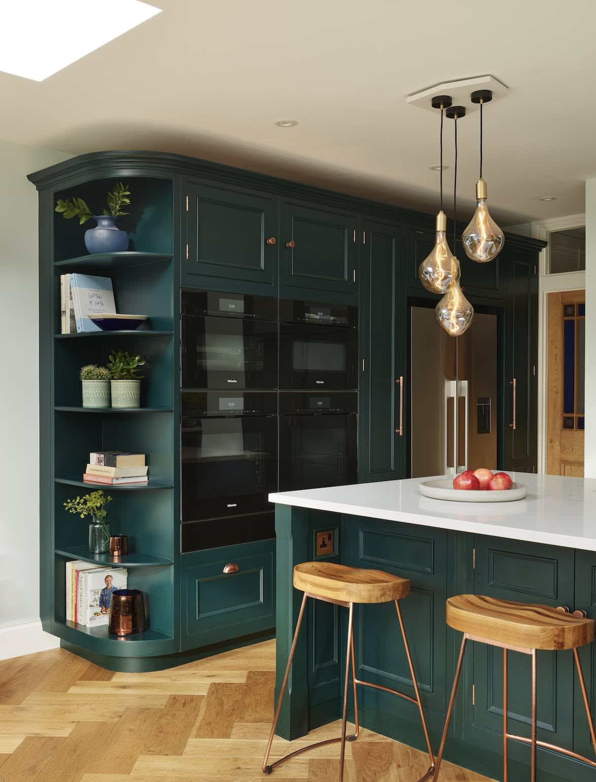 Vibrant green Original design kitchen cabinetry with integrated appliances and organised corner shelving