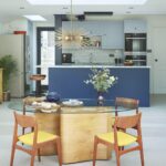 Open plan dining area overlooking a blue Shaker kitchen