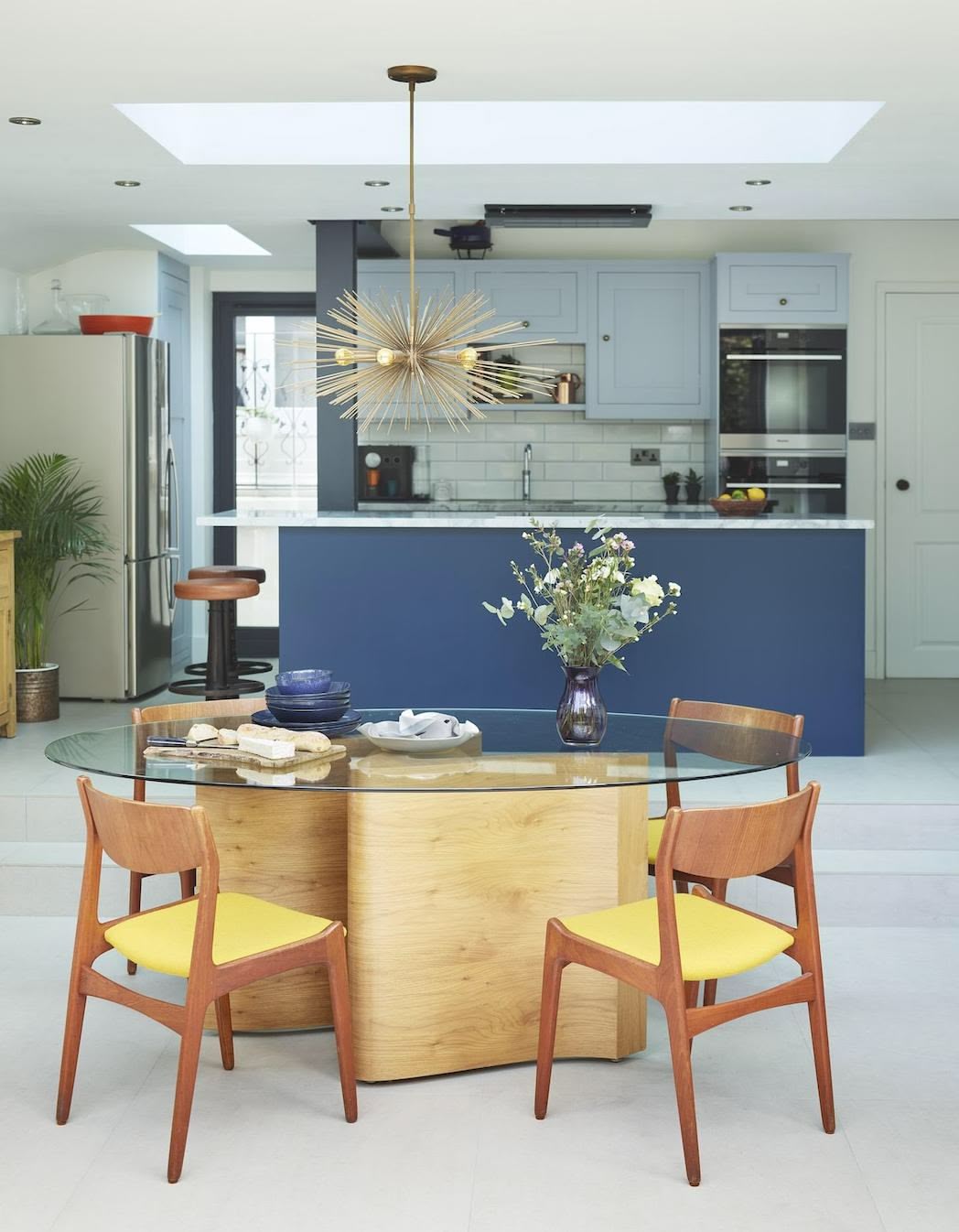 Open plan dining area overlooking a blue Shaker kitchen