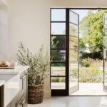 Deep green Shaker kitchen design with large glass door to the garden