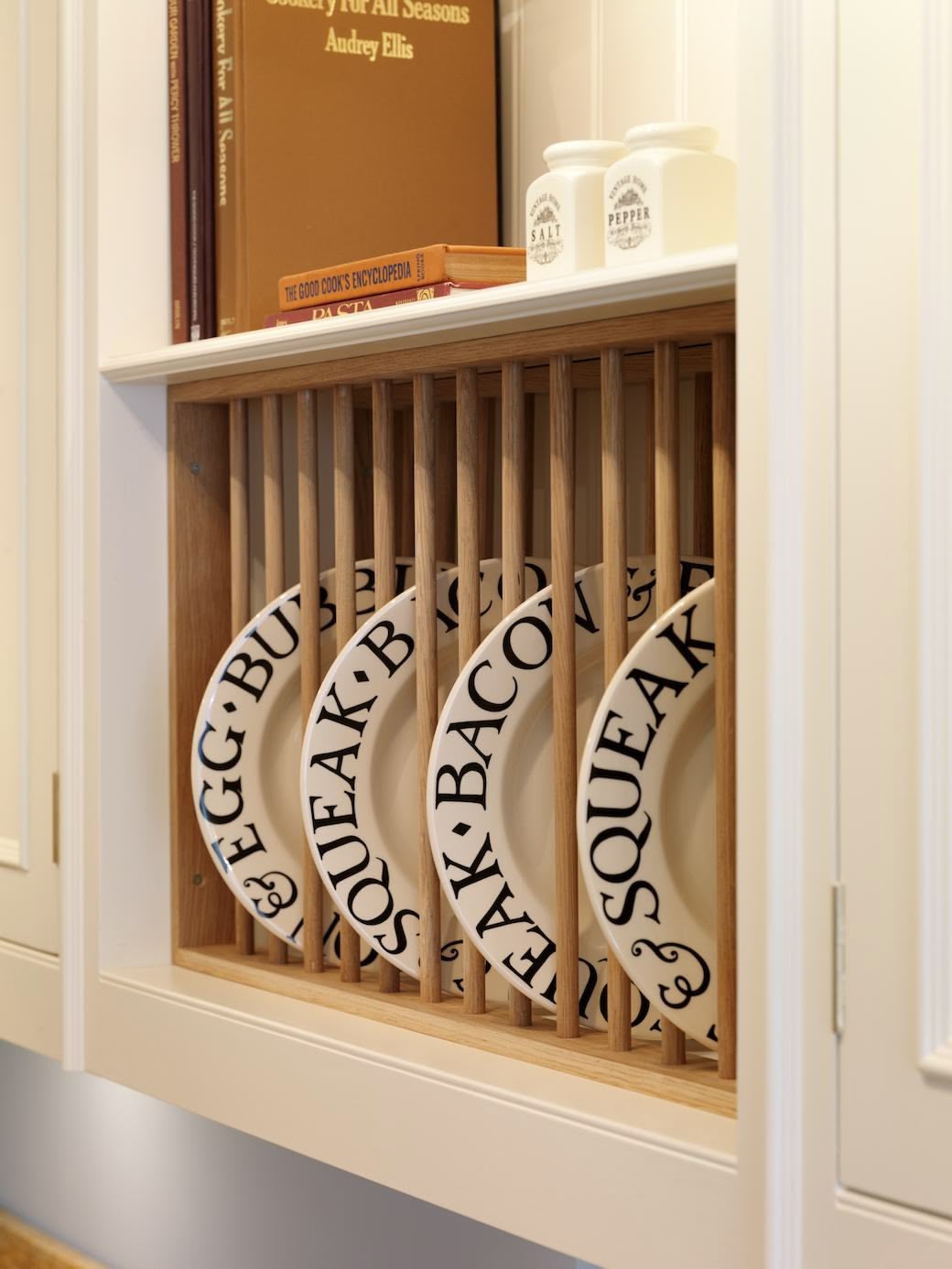 White kitchen cabinet with oak interior with open plate rack