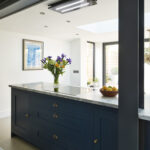 Blue Shaker kitchen island with white granite worktop seen through external window