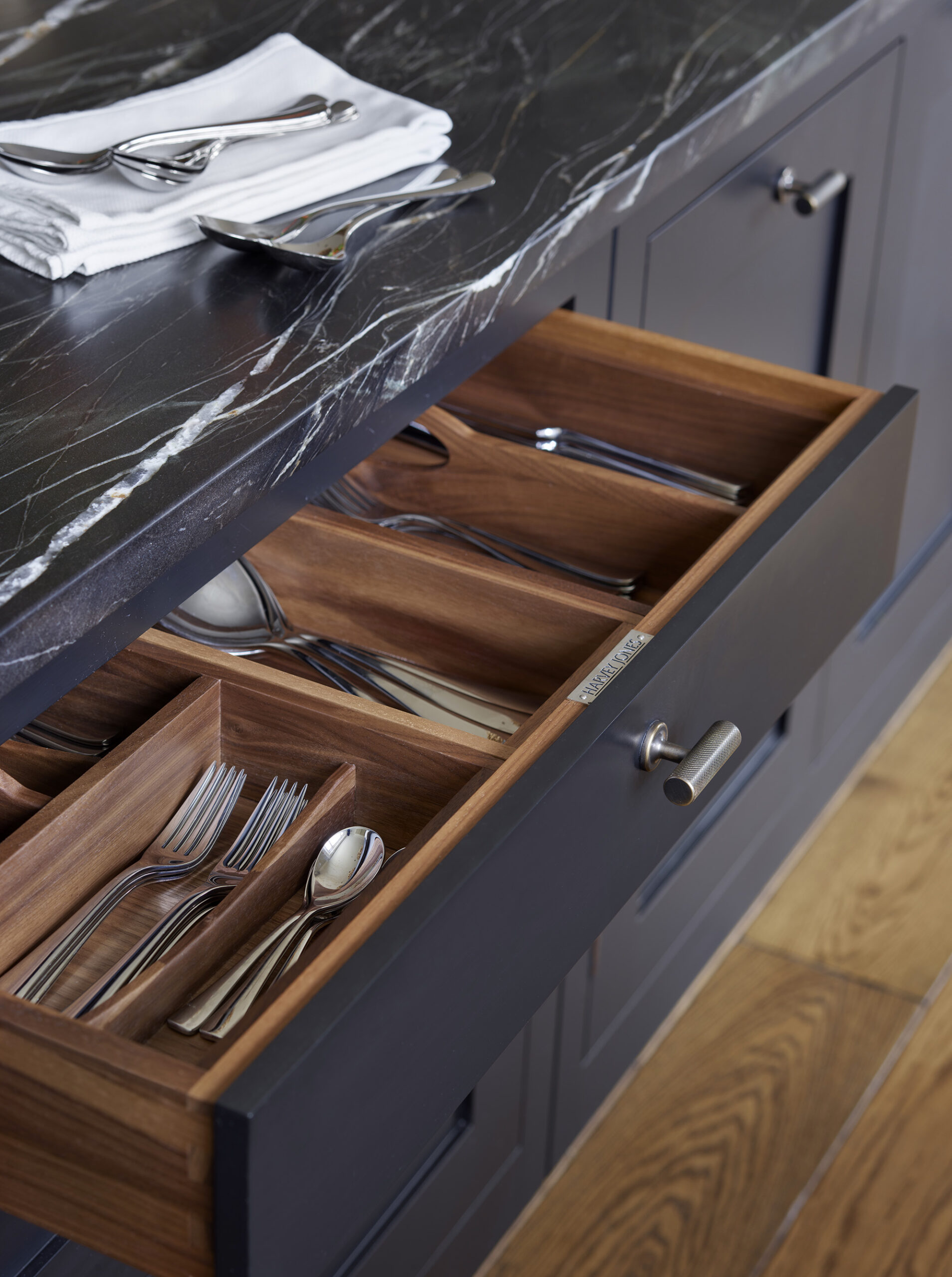 Black Shaker kitchen drawer open to show walnut interior