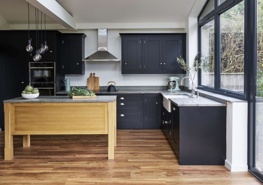 Black Shaker kitchen cabinetry with oak kitchen island and grey worktops