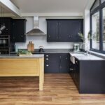 Black Shaker kitchen cabinetry with oak kitchen island and grey worktops
