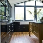 Black Shaker kitchen cabinetry with oak kitchen island and grey worktops