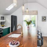 Bold green Shaker kitchen cabinetry with walnut kitchen island worktop